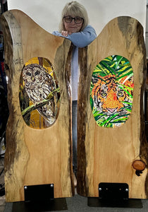 two large pine live edge panels.  Once featuring a stained glass mosaic barred owl and the other displaying a tiger.   The mosaics are created on clear glass therefore they take on a different hue with light sources.